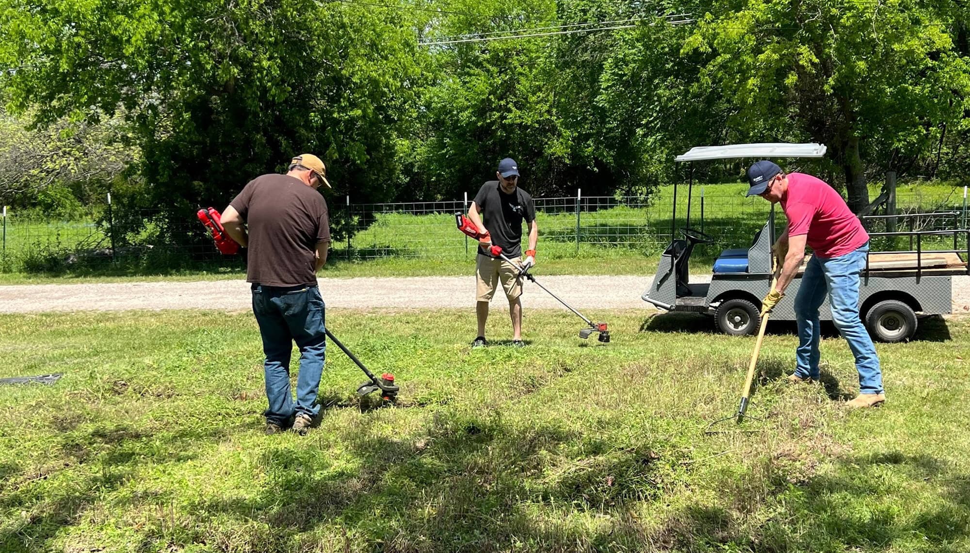 Volunteers cleaning up a yard with tools