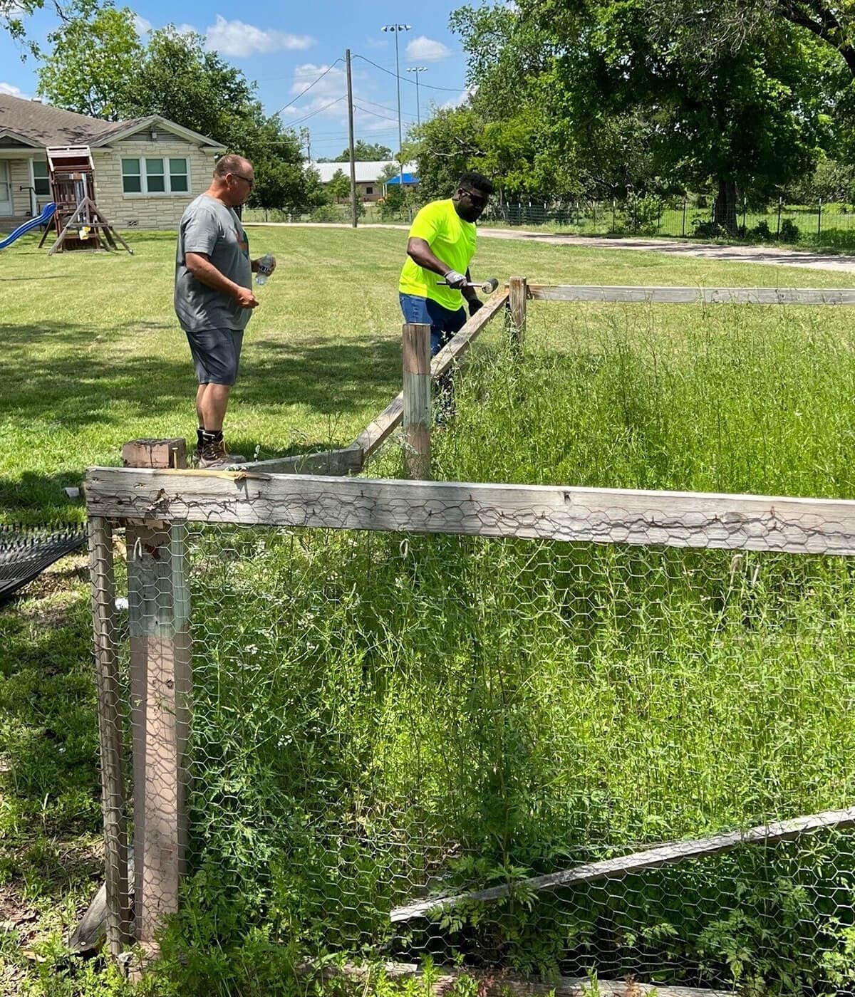 Volunteers taking apart an old fence