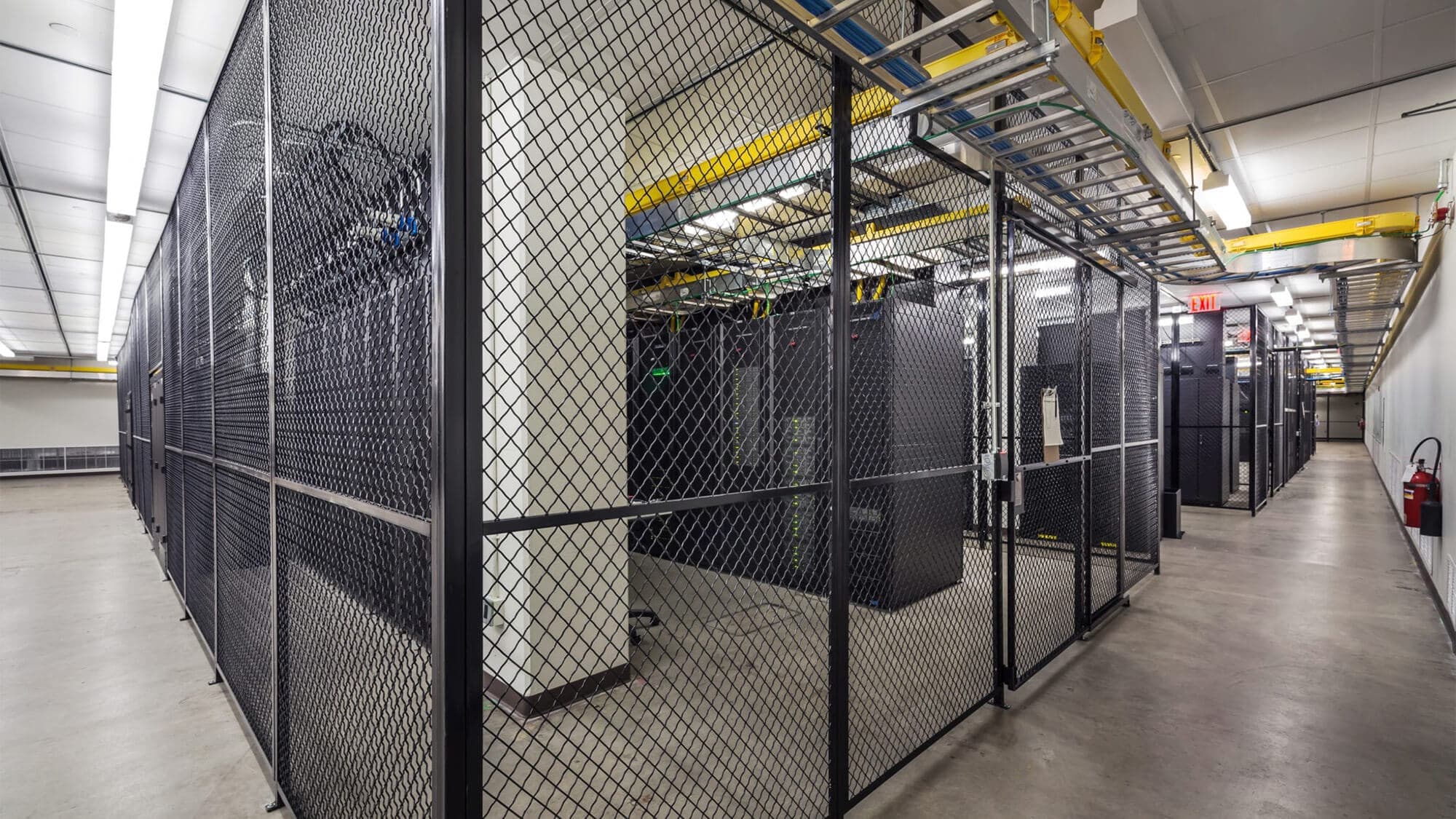 Industrial room with servers behind a chain link gate