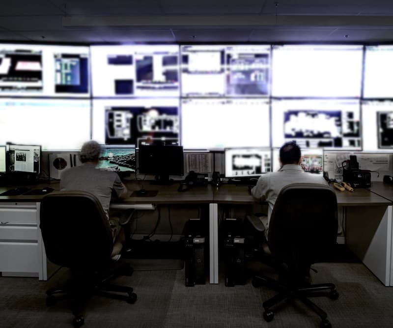 Sabey data center control room with multiple computer screens and two operators