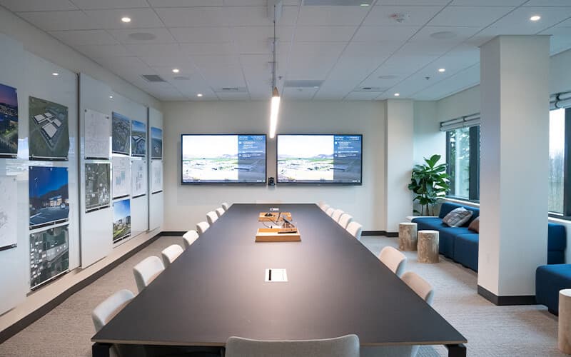 Conference room with long table and digital screens