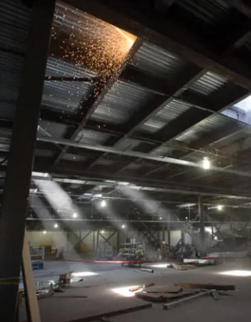 Inside of a building under construction with sparks coming form a ceiling section.
