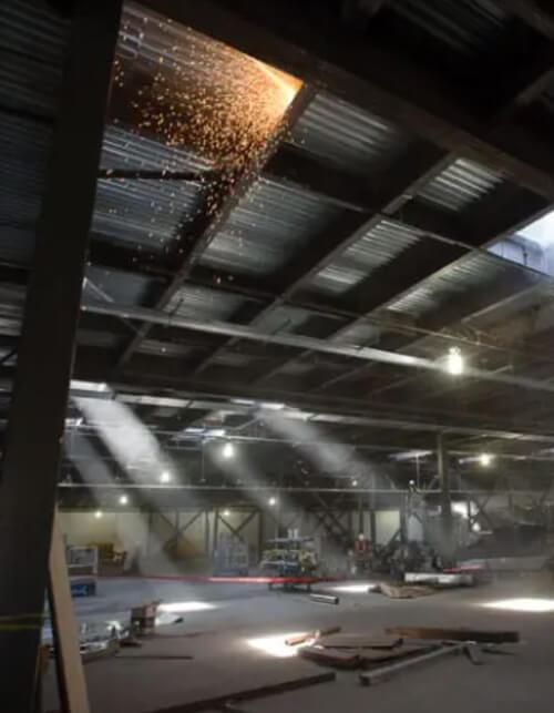 Inside of a building under construction with sparks coming from a ceiling section.