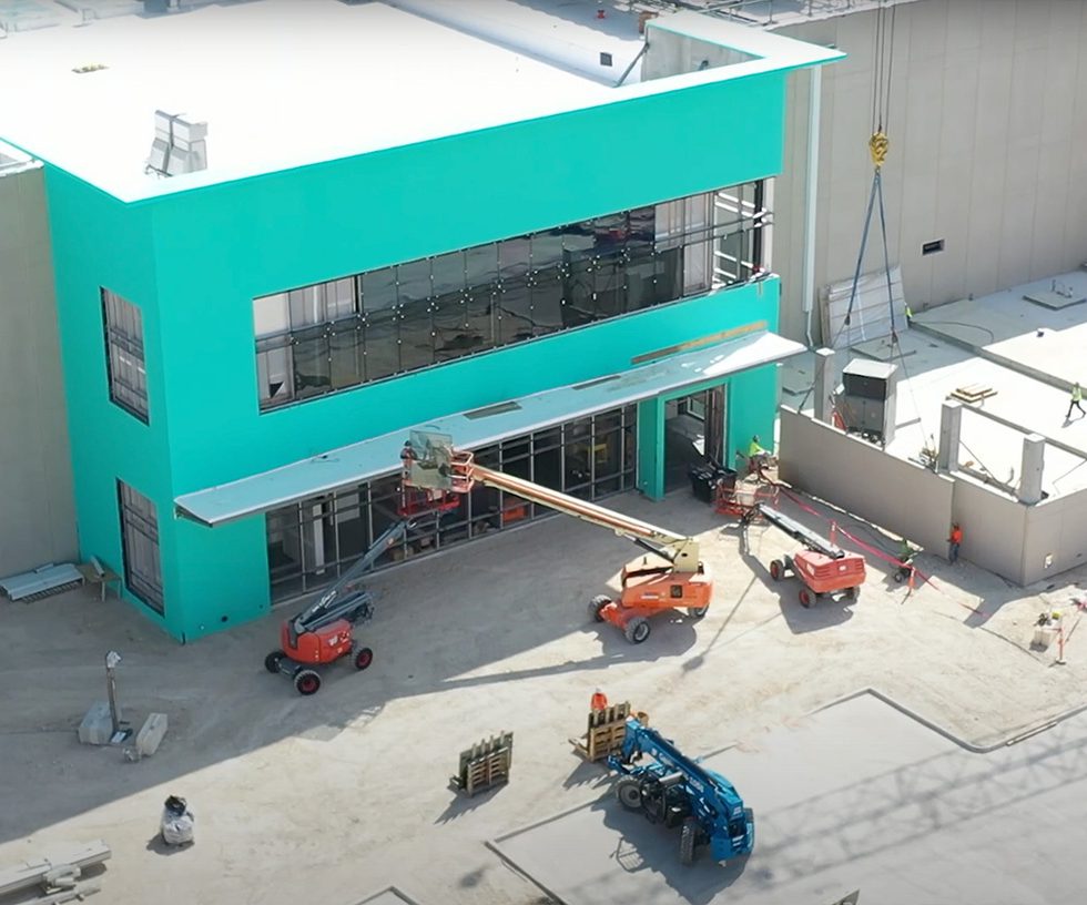 Construction vehicles around the facade of a new building
