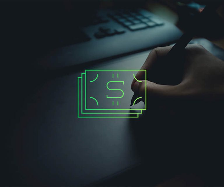 Hand holding stylus in front of a computer with a green icon representing money