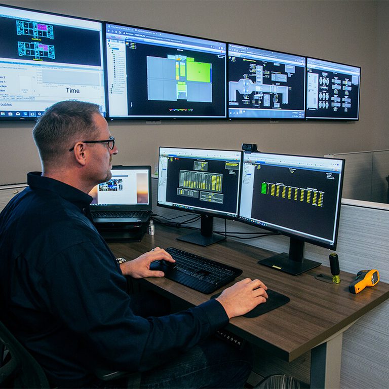 person reviewing data on several computer monitors