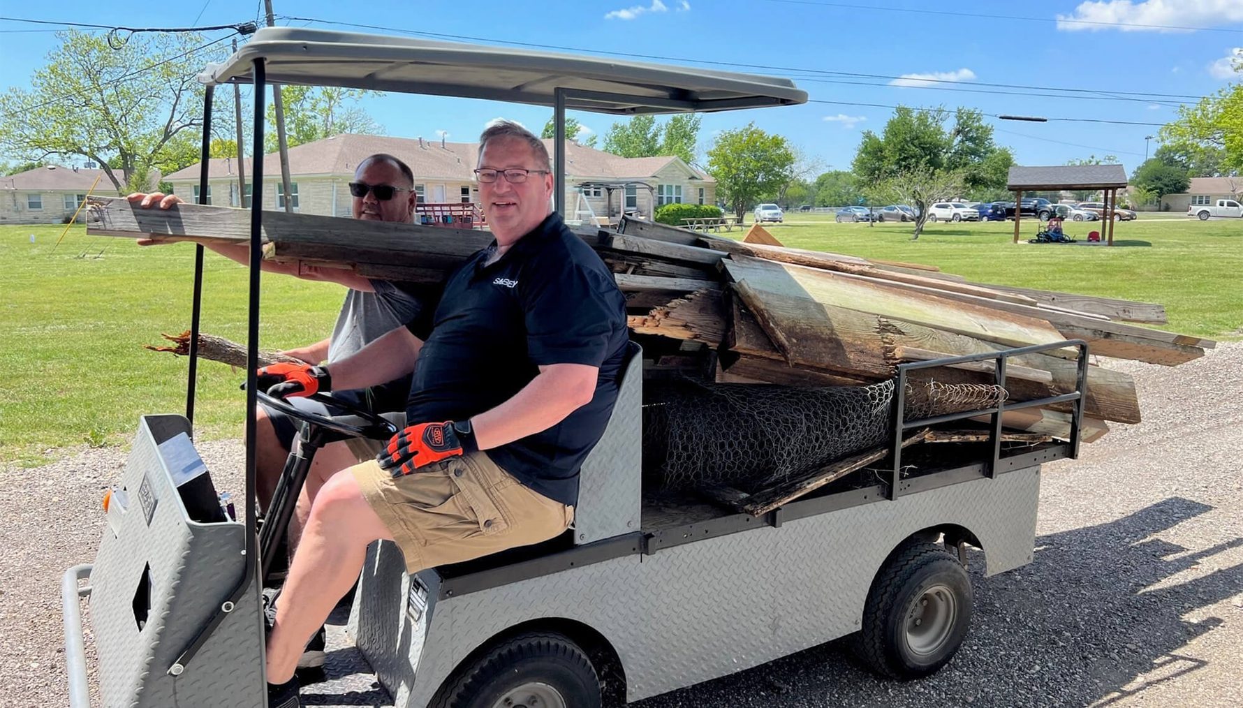 Volunteers driving a small truck of scrap lumber