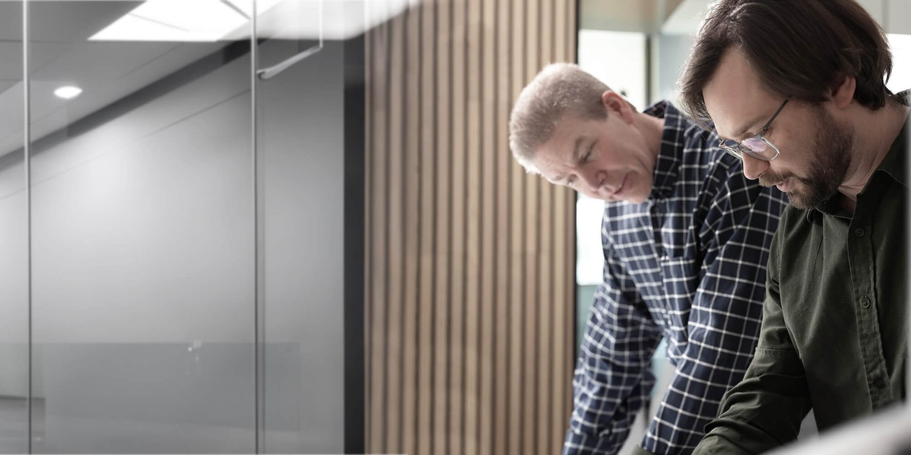 Two office workers discuss a plan in a conference room