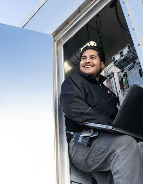 Worker with laptop doing maintenance on a data center