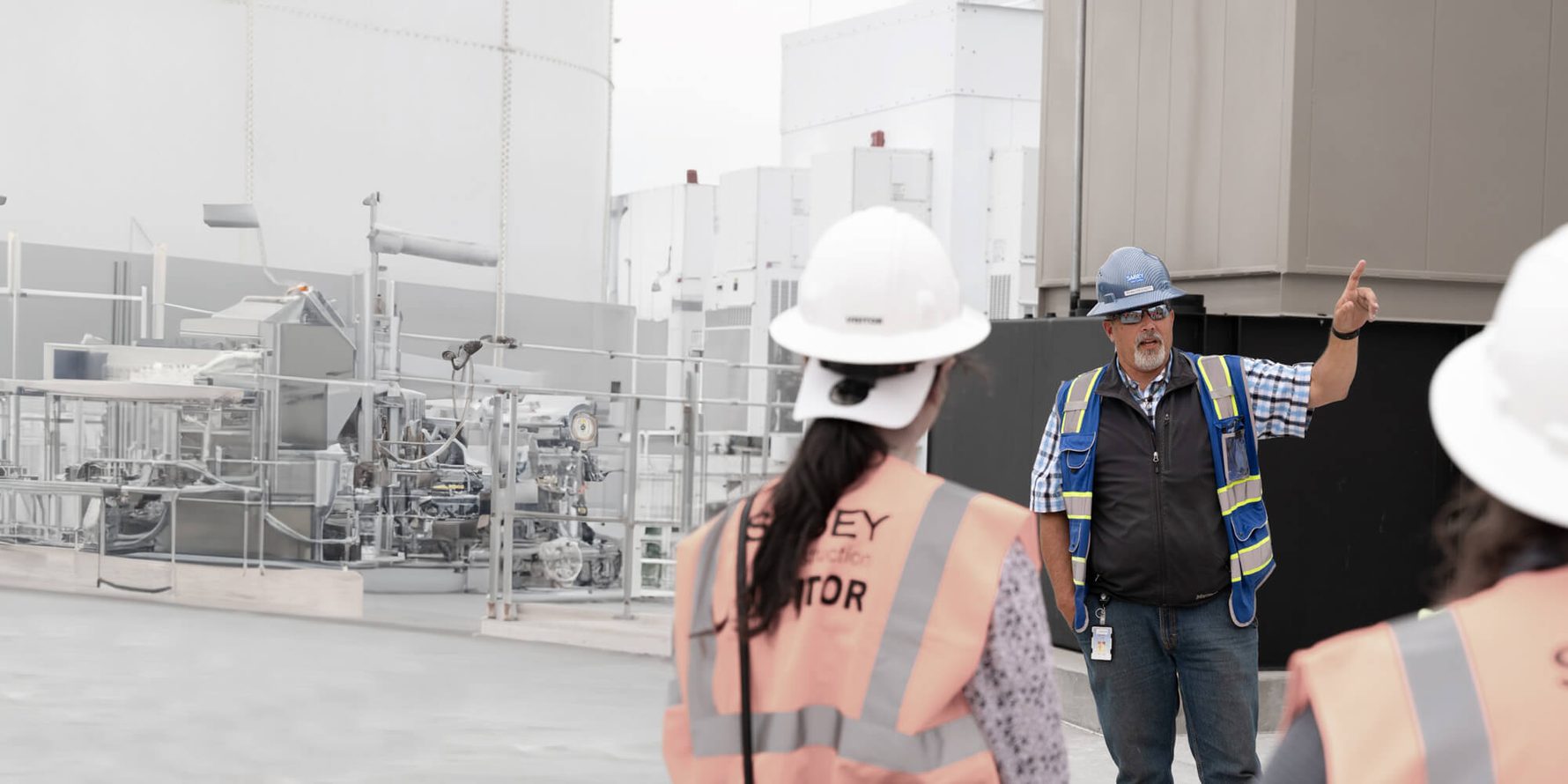 People in safety gear touring the roof of a data center facility
