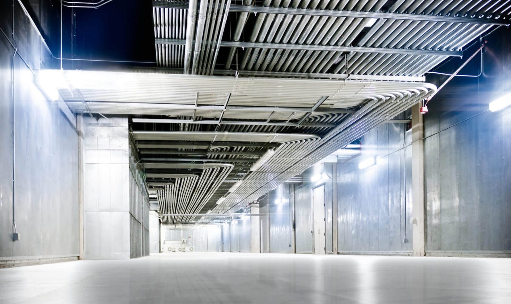 A large open floor area with pipes running along the ceiling.